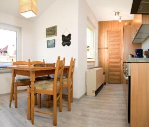 Il comprend une cuisine et une salle à manger avec une table et des chaises en bois. dans l'établissement Meertied, à Oertzenhof