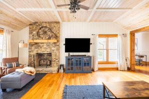 sala de estar con TV y chimenea de piedra en Golden Acres Ranch Hot Tub+Gameroom+Creek & wifi en Highlands
