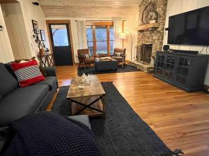 sala de estar con sofá y chimenea en Golden Acres Ranch Hot Tub+Gameroom+Creek & wifi en Highlands