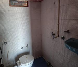 un piccolo bagno con un water e un lavandino di Gujrati Marwadi Cottage by StayApart a Barkot
