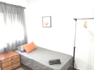 ein Schlafzimmer mit einem Bett und einer Kommode mit einer Tasche darauf in der Unterkunft Típico apartamento de pueblo in Faura