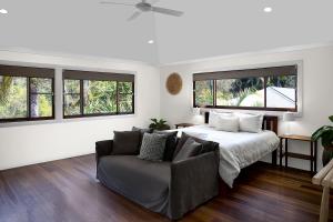 a bedroom with a bed and a couch and windows at Away Guesthouse- Away on Shirley Lane in Byron Bay +49 photos