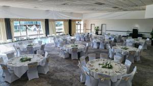 una habitación llena de mesas y sillas con ropa de cama blanca en Barrack Point Holidays, en Barrack Point 31 fotos más