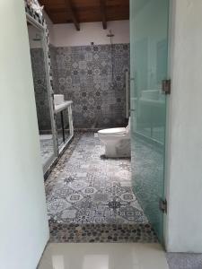 a bathroom with a toilet and a glass shower at Casa Tamarindo in Alpuyeca