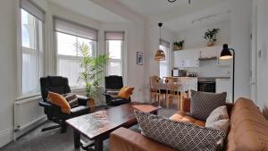 - un salon avec un canapé, des chaises et une table dans l'établissement Fernhurst holiday apartments, à Shanklin