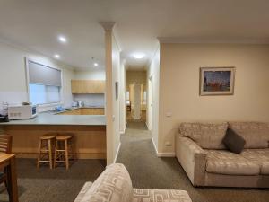 a living room with a couch and a kitchen at Mary MacKillop Heritage Centre in Melbourne