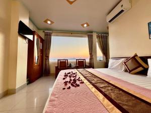 een slaapkamer met een bed en uitzicht op de oceaan bij Manh Vuong Hotel in Cat Ba