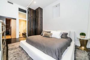 a bedroom with a large bed with white walls at Luxurious 3 BR/2BA Beautifully Renovated Loft in New York