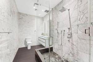 a bathroom with a shower and a toilet and a sink at Luxurious 3 BR/2BA Beautifully Renovated Loft in New York