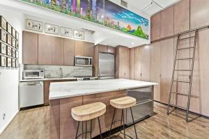 a kitchen with a counter and two stools at Luxurious 3 BR/2BA Beautifully Renovated Loft in New York