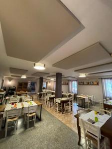- une salle à manger avec des tables, des chaises et des fenêtres dans l'établissement Hotel La Cascina, à Fontanellato
