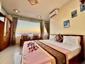 a bedroom with a bed with a view of the ocean at Manh Vuong Hotel in Cat Ba