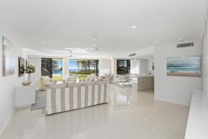 una sala de estar blanca con muebles blancos y vistas al océano. en The Garland at Rainbow Bay, en Gold Coast