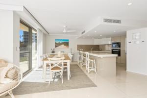 a kitchen and dining room with a table and chairs at The Garland at Rainbow Bay in Gold Coast