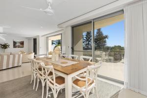 uma sala de jantar e sala de estar com mesa e cadeiras em The Garland at Rainbow Bay em Gold Coast