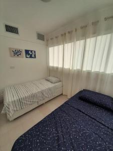 1 dormitorio con 2 camas y ventana en Executive Style Condo With Sea Views en Porlamar