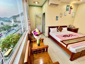 a bedroom with a bed and a large window at Manh Vuong Hotel CatBa in Cat Ba