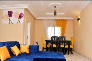 a living room with a blue couch and a table at Appartement meublé, 2 douches, 2 chambres in Yaoundé