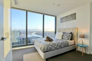 a bedroom with a bed and a large window at Nest Apartments Meet Upper West Side in Melbourne +71 photos