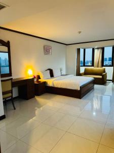 Omni Tower Sukhumvit Nana by Direct Rooms في بانكوك: غرفة نوم بسرير ومكتب واريكة