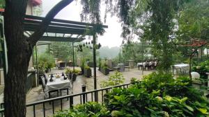 a patio with a table and chairs in a garden at 7 Pines Kasauli in Kasauli