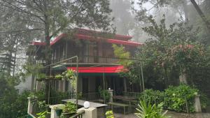 a house with a red roof in the forest at 7 Pines Kasauli in Kasauli