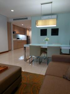 een woonkamer met een bank en een eettafel bij The H Tower Residence by YLS Stay in Jakarta