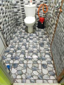 La salle de bains est pourvue de toilettes et de carrelage. dans l'établissement ABAH HOMESTAY, MANIR, KUALA TERENGGANU, (HOMESTAY B), à Kuala Terengganu
