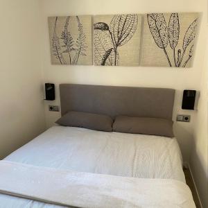 a bed in a bedroom with two pictures on the wall at New Apartment La Massana - Telecabina to Bike Park in La Massana