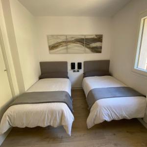 twee bedden in een kleine kamer met ermottermottermott bij New Apartment La Massana - Telecabina to Bike Park in La Massana