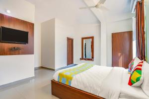 een slaapkamer met een bed en een flatscreen-tv bij OYO Dream Connect Stays Near City Center Mall in Hyderabad