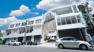 a white building with cars parked in front of it at Hotel Grand Square in Yercaud