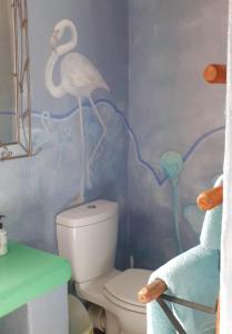 a bathroom with a toilet with a bird painted on the wall at Gecko Cottage at Artemis in Franschhoek