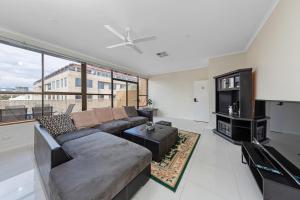 a living room with a couch and a large window at Tuggeranong Short Stay #11C - Sleeps 8 in Canberra