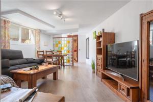 Una sala de estar con un televisor de pantalla plana grande. en Apartment Lyon - Alcúdia - ETVPL15408, en Alcudia