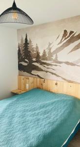 a bedroom with a bed with a mountain mural on the wall at Appartement familial station de Peyragudes in Germ