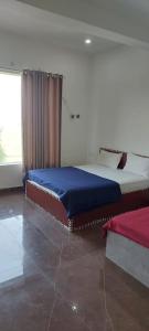 um quarto com uma cama grande num quarto com uma janela em Saritashray Seva Dham em Vrindavan