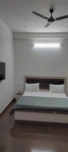 um quarto com uma cama grande e uma ventoinha de tecto em Saritashray Seva Dham em Vrindavan