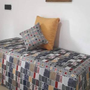 a bed with two pillows sitting on top of it at Departamentos Ojos del Alma in Valeria del Mar +26 photos