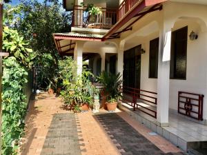 uma casa com varanda e vasos de plantas em Belle Maison F3 em Papeete