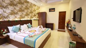 a bedroom with a large bed with shoes on it at Hotel Grand Square in Yercaud