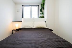 1 dormitorio con 1 cama grande y ventana en KooKai en Yaka