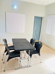 a meeting room with a table and four chairs at A Home Away From Home in Mawere