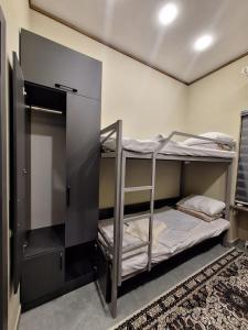 a room with two bunk beds and a rug at Al-Hilal Hostel in Samarkand