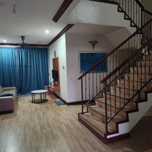 sala de estar con escalera y sofá en KB Homestay - Free WIFI, en Kota Bharu