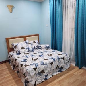 uma cama num quarto com paredes azuis e cortinas azuis em KB Homestay - Free WIFI em Kota Bharu