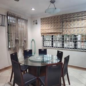 uma sala de jantar com uma mesa de vidro e cadeiras em KB Homestay - Free WIFI em Kota Bharu