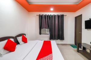 - une chambre avec un lit doté d'oreillers rouges et une fenêtre dans l'établissement OYO Flagship 62748 Hotel Zeenat, à Jammu