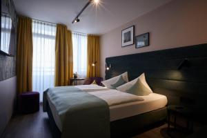 a hotel room with a large bed and a window at Hotel Mirabell by Maier Privathotels in Munich