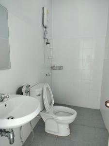 a white bathroom with a toilet and a sink at VS appartment in Vientiane